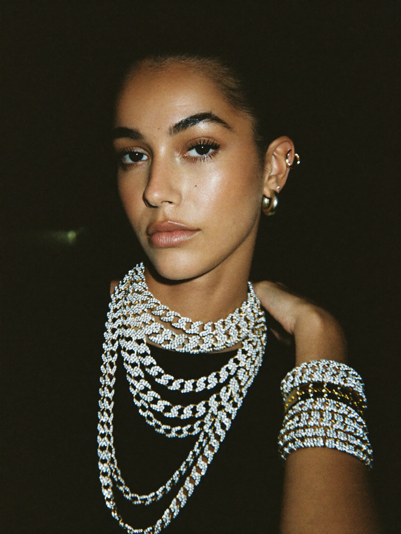Model wearing stacked iced chains and tennis bracelets