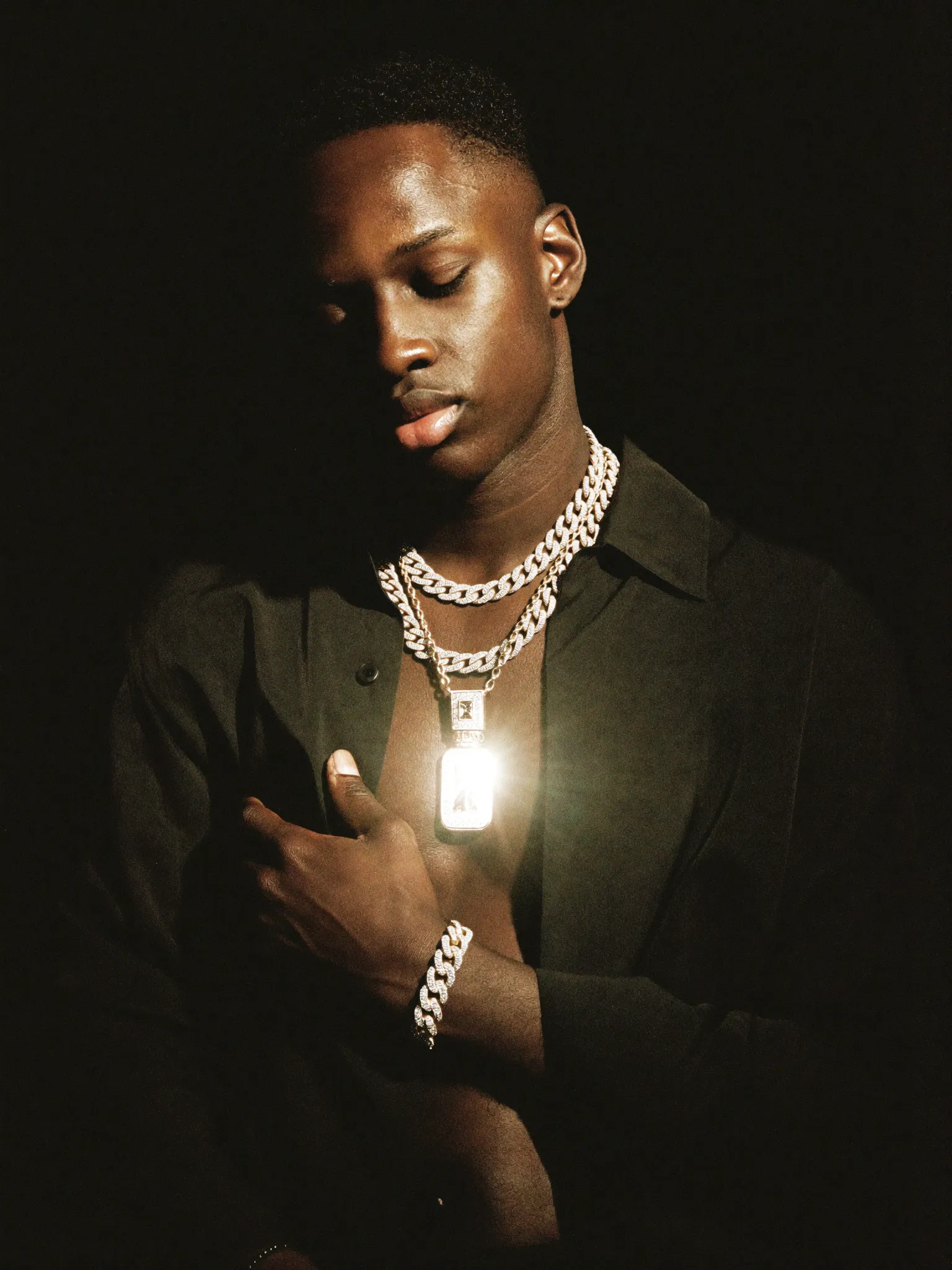 Model wearing layered iced Cuban chains and a pendant